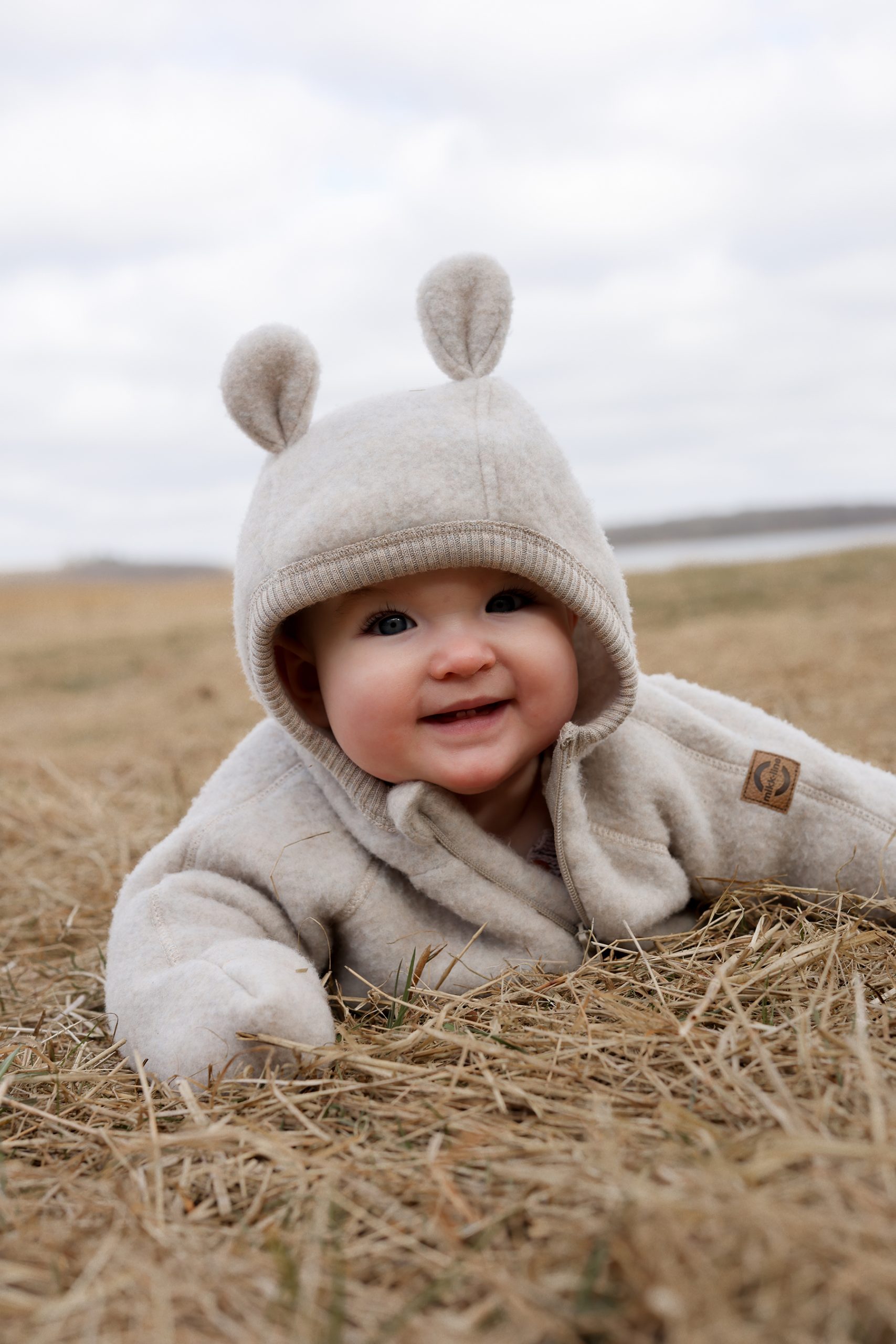 50041 - Wool Baby suit w ears - Melange Offwhite - Extra 10 kombinezon merino, kombinezon z uszami misia dla niemowląt, kombinezon dla dzieci biały merino, wełna merynosów dla dzieci, 100% wełna merino Hello Berry, Mikk Line kombinezon merino